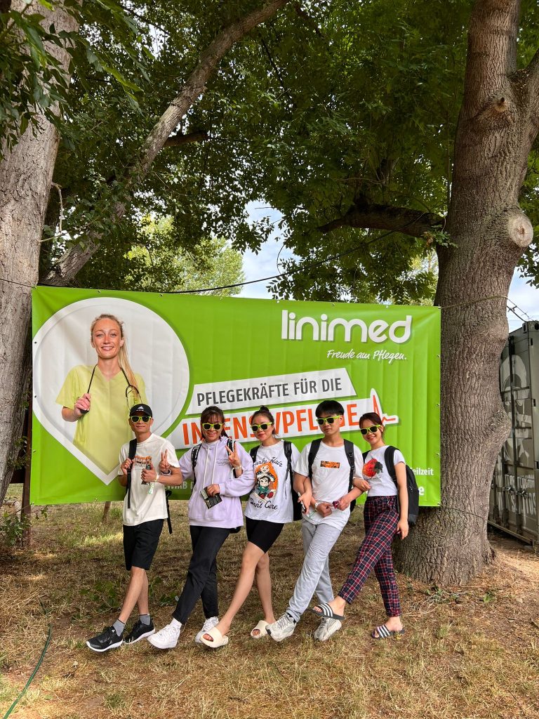 Fünf junge Menschen posieren vor einem Banner der Linimed GmbH.